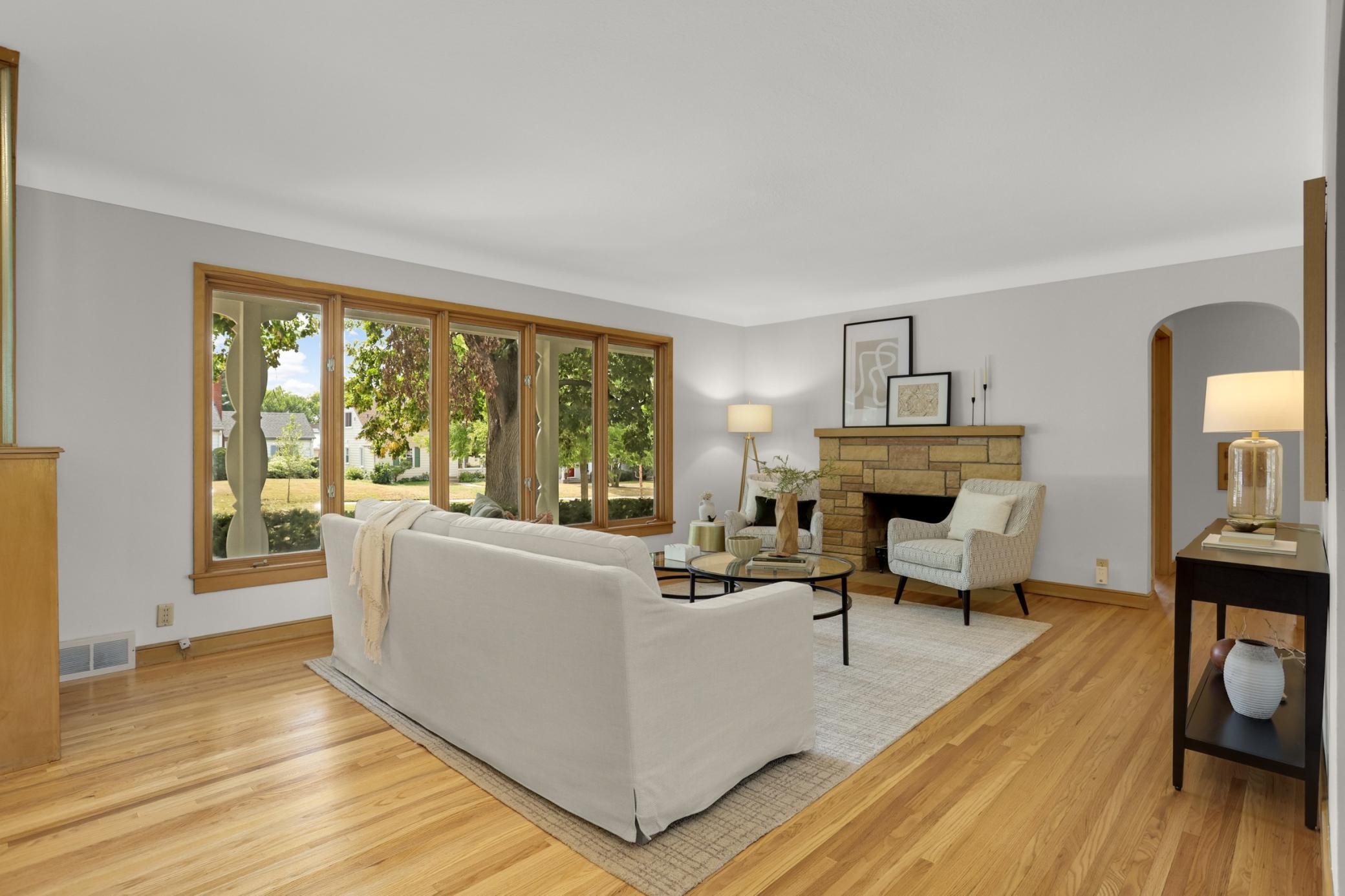 Living room is flooded with natural light and features a stone fireplace
