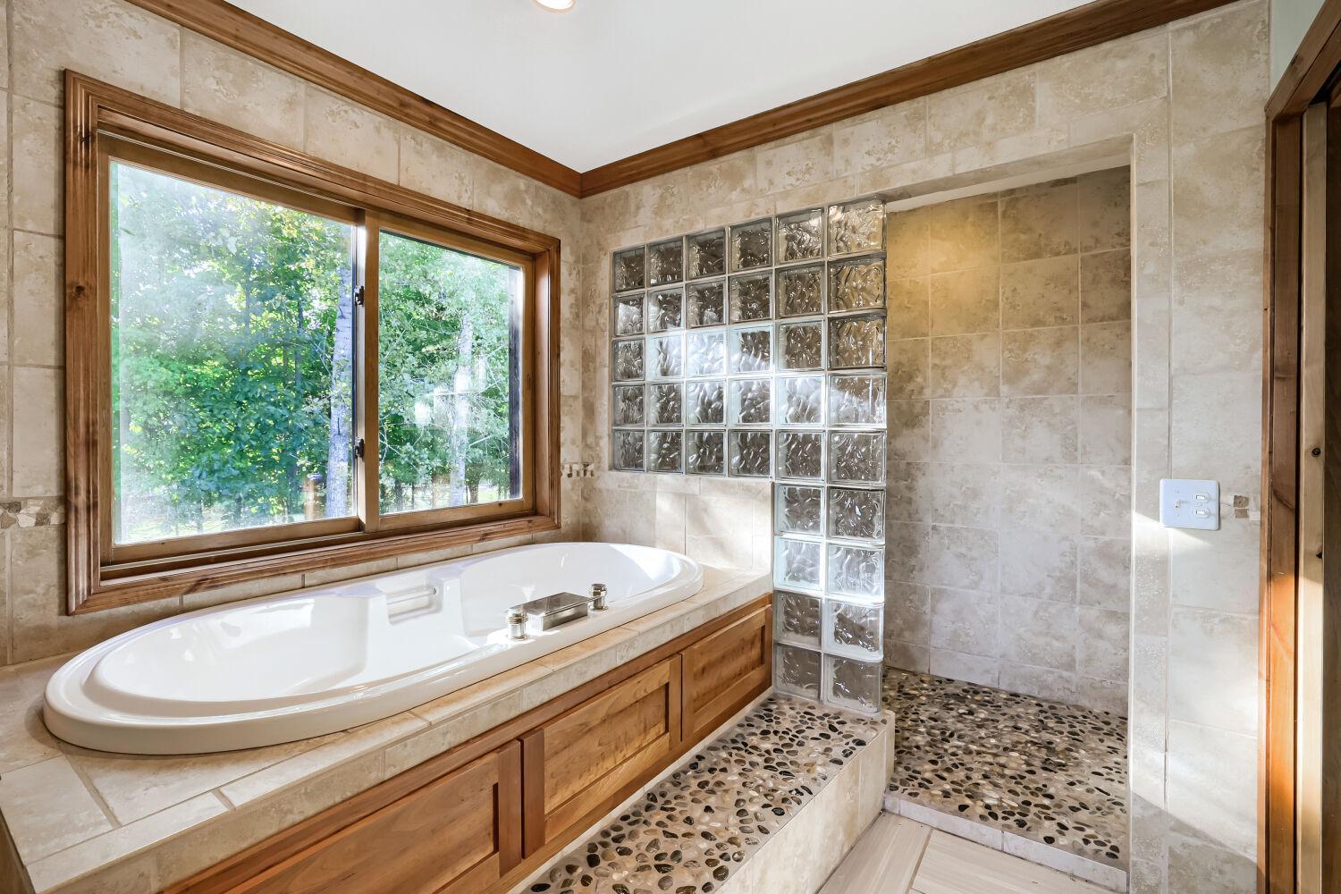 Primary bath with jetted tub and river rock walk-in shower.