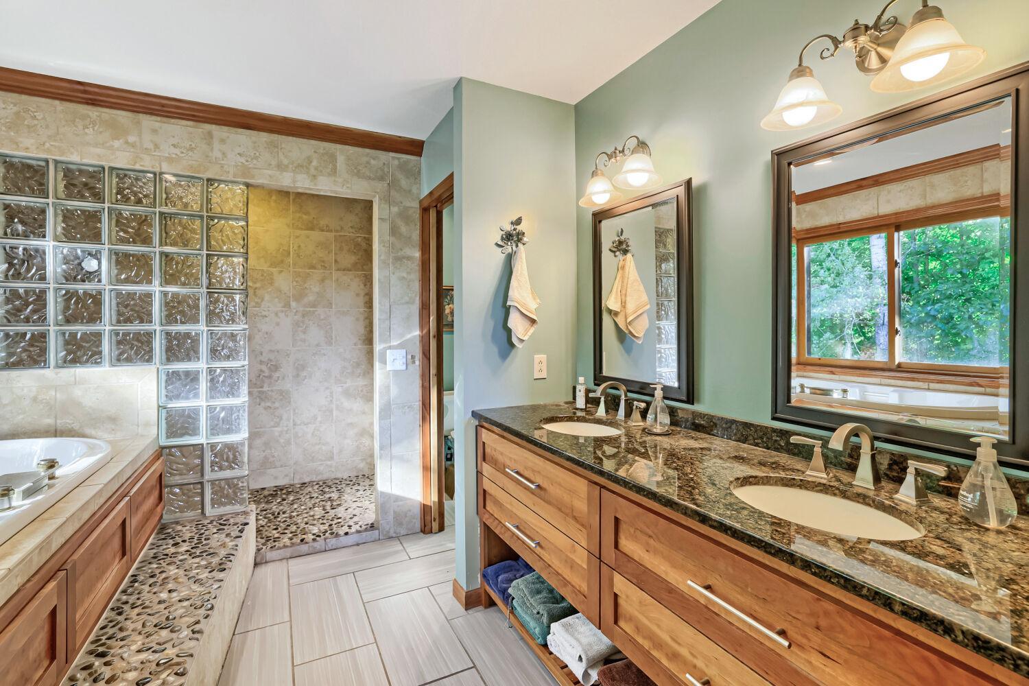 Primary bath with dual sinks and granite countertops.