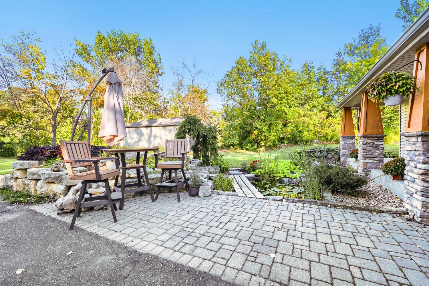 A paver patio adjoins the pond in the front yard.