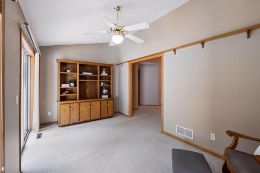 Another beautiful view of the sunroom featuring vaulted ceilings and a thoughtful transition from the living room, creating separation while maintaining an open feel and easy access to the patio.