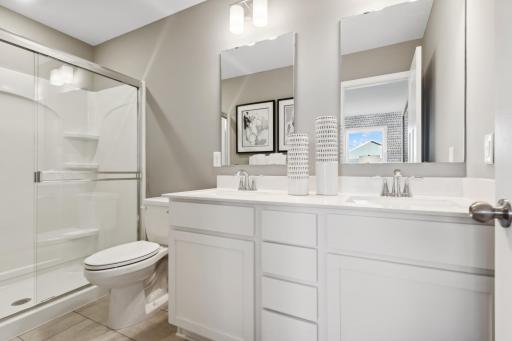 (Photo of a decorated model, actual homes finishes will vary) An extension of the primary bedroom, this private and spacious bath includes a double vanity and shower.