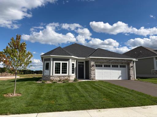 Pulling up to the home you see a breathe taking three windows along with beautiful architecture and landscape.