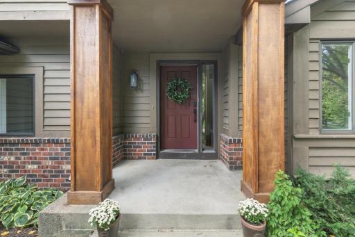 Inviting covered front entry features cedar craftsman style columns