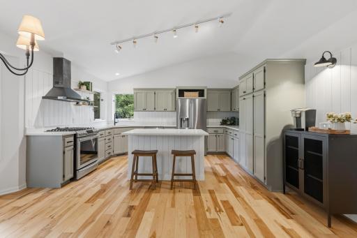 The Kitchen offers enameled cabinetry that features flat panel doors, full height pantry, floating white oak shelves and an oversized "Eat-In" center island wrapped in shiplap