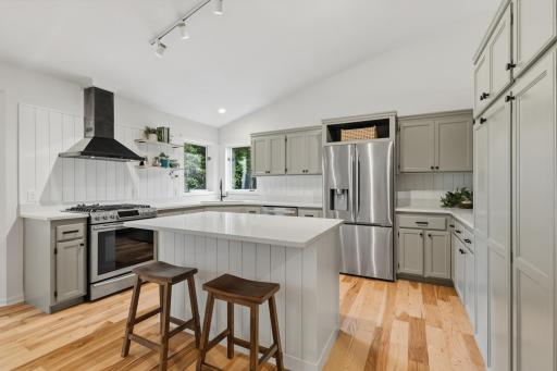 Stainless steel appliances French door refrigerator, gas range with decorative hood and dishwasher