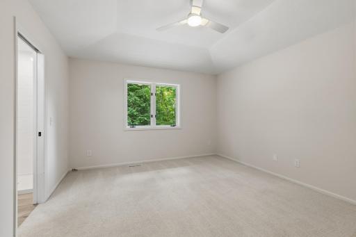 Master Bedroom features large windows that capture treetop views of the property and is very spacious