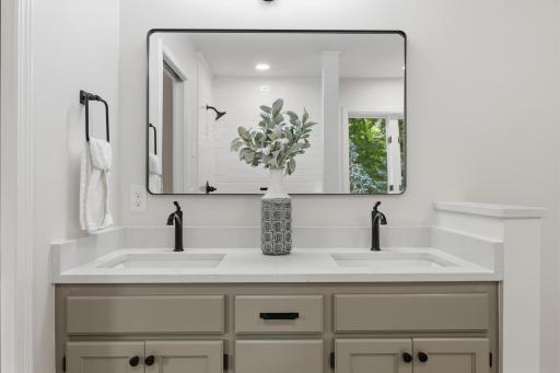Master Bathroom features enameled vanity cabinet with dual sink and quartz countertops