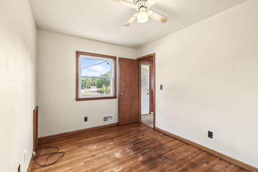 Additional bedroom view showcasing hardwood floors, a window for natural light, and a comfortable layout.