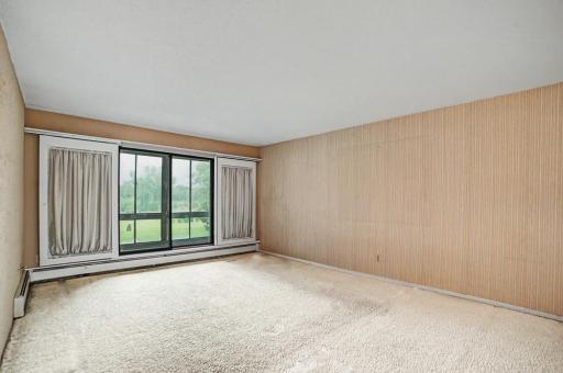 Living room with south facing sliding glass doors leading to screened porch + lawn