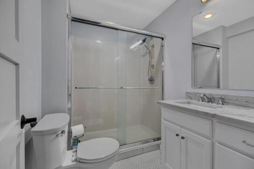 Updated lower-level 3/4 bathroom featuring a modern look and refreshed finishes.