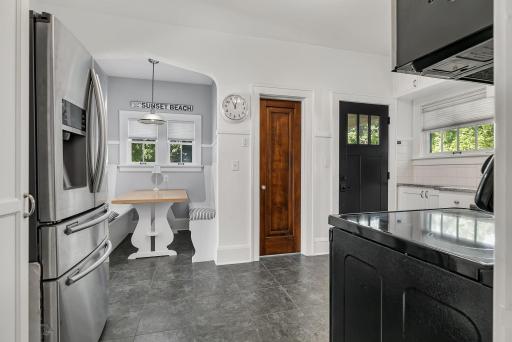Another view of the inviting kitchen, highlighting the built-in dining nook and warm, welcoming feel.
