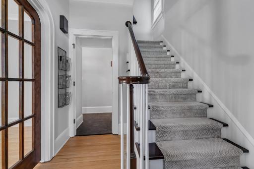 Charming staircase featuring carpeted steps and a classic banister, adding warmth and character to the homeâs interior.