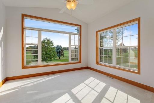 Sunroom is vaulted with ceiling fan and southern views of the golf course