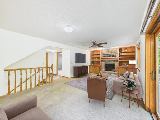 Picture evenings by the gas fireplace in this main-level family room with custom built-ins. Virtually staged.