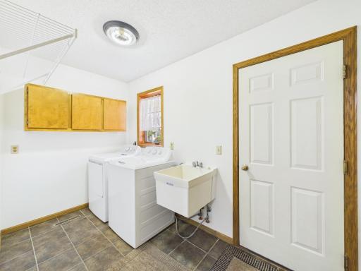 Convenient main-level laundry with a utility sink and storage.