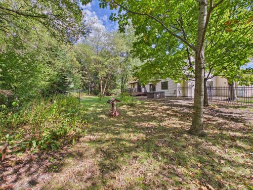 Mature trees and a fenced yard create a tucked-away outdoor setting at this Chaska home.