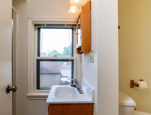 Upper level 3/4 bath has vanity and shower area with window and a separate toilet area.