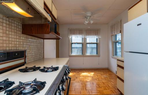 Kitchen leading to a good sized dining area with wood parquet flooring.
