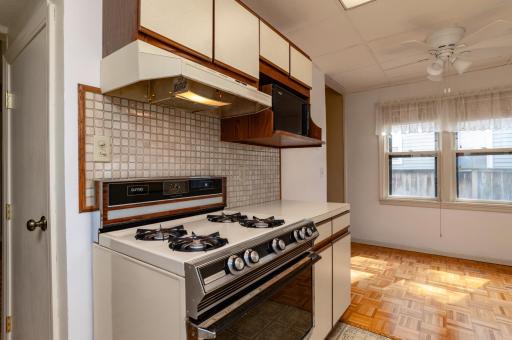 Close access door to lower level basement. Kitchen features gas stove, hood fan and microwave shelf.