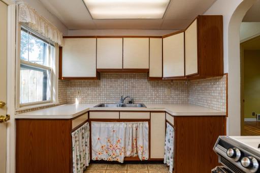 Another kitchen window allows for lots of natural light in this kitchen. Archway to main floor hallway leading to Living Room, main floor bedroom and full bathroom.