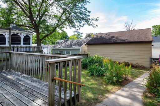 Backyard with sidewalk access to oversized double garage.