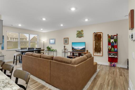 Spacious open-concept main floor featuring inviting living, dining & kitchen areas with luxury LVP flooring, granite countertops, stainless-steel appliances, and a gas range—perfect for everyday living and entertaining.