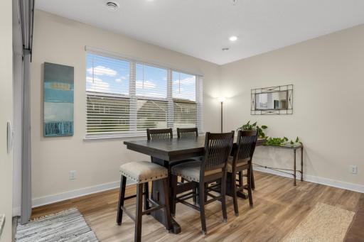 Inviting dining area filled with natural light, featuring a sleek sliding glass door that opens to the covered patio—creating an effortless flow between indoor and outdoor living and providing the perfect setting for everyday meals or entertaining.