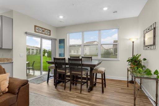 Inviting dining area filled with natural light, featuring a sleek sliding glass door that opens to the covered patio—creating an effortless flow between indoor and outdoor living and providing the perfect setting for everyday meals or entertaining.
