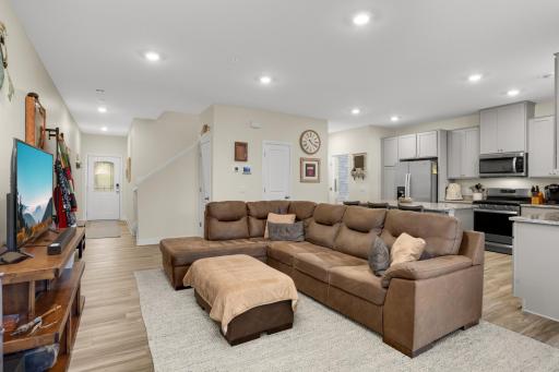 Spacious open-concept main floor featuring inviting living, dining & kitchen areas with luxury LVP flooring, granite countertops, stainless-steel appliances, and a gas range—perfect for everyday living and entertaining.