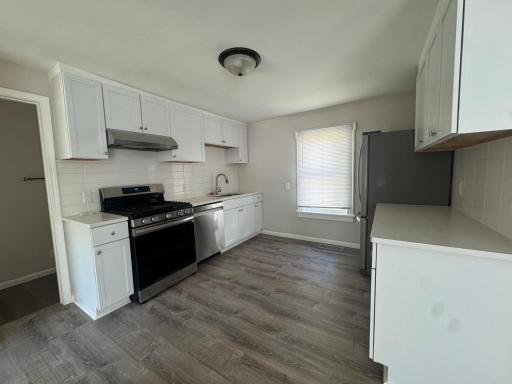 Spacious living area with luxury vinyl plank flooring and abundant natural light