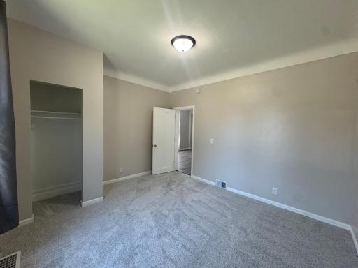 Spacious bedroom with plush carpet and a large closet