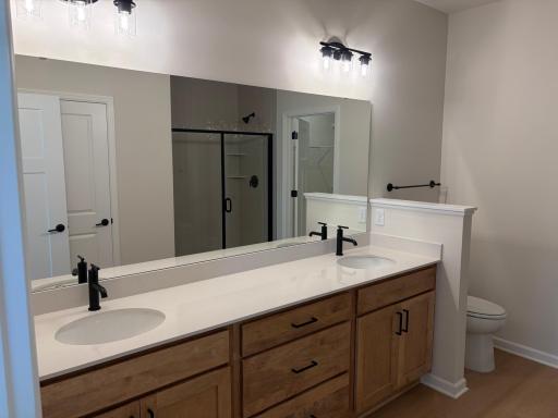 Featuring a duel vanity and plenty of counter space. The owner's bath makes getting ready a breeze. Model photo (Home under construction)