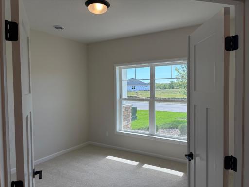 Featuring French doors the immediate bedroom is spacious enough for an office, queen size bed or a secondary den. Model photo (Home under construction)