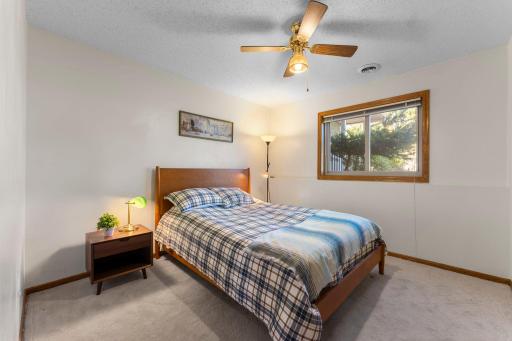 Large daylight windows bring abundant natural light into the lower-level bedrooms. 4th bedroom with large window, ceiling fan with light, newer carpeting and ample closet space