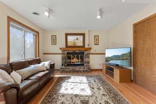 Spacious family room features light oak laminate flooring and a warm, inviting atmosphere. Fireplace features a raised hearth and custom oak mantel for timeless character.