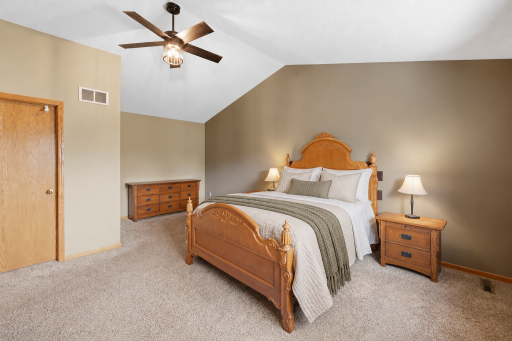 A spacious primary bedroom with walk-in closet, en suite primary bathroom and vaulted celings.