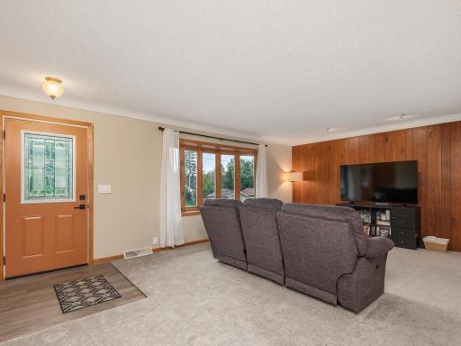 Comfortable living room with new carpeting and natural wood accents.