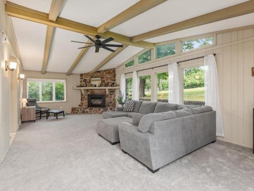 Impressive great room with vaulted ceilings, exposed beams, and a gas stone fireplace.