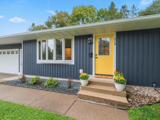 Cheerful new front door and refreshed landscaping add welcoming curb appeal.