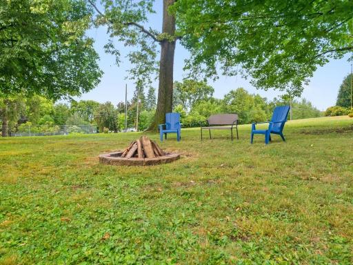 Gather around the backyard fire pit beneath the mature shade trees.