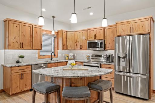 Warm wood cabinetry pairs with granite counters and stainless steel appliances.