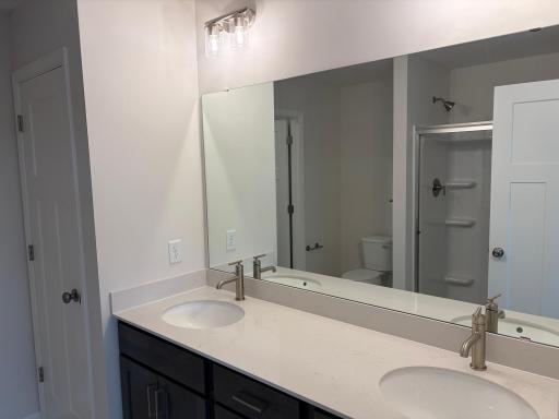 Dual vanity in the private en-suite bath provides maximum functionality. Features a large shower.