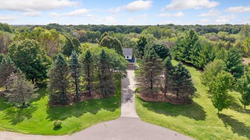 Aerial view of the home. Treed for privacy, long concrete drive, and cul-de-sac lot.