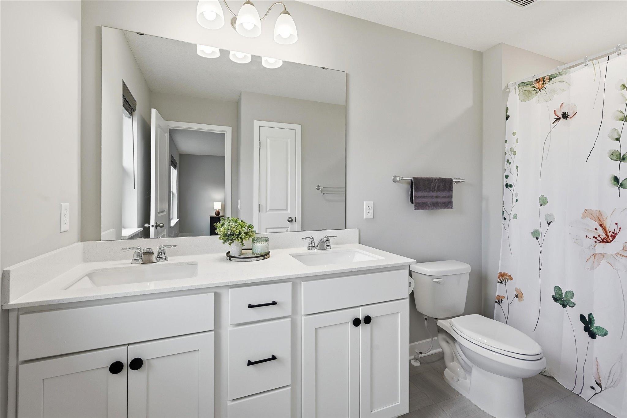 A private full bathroom with dual sinks provide generous counter space and make morning routines a little easier.