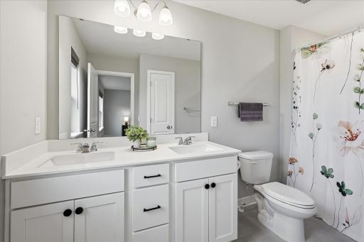 A private full bathroom with dual sinks provide generous counter space and make morning routines a little easier.