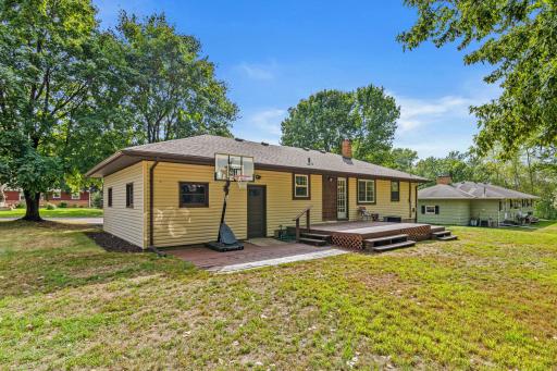 Large deck and adjacent patio offer plenty of options for seating and grilling.