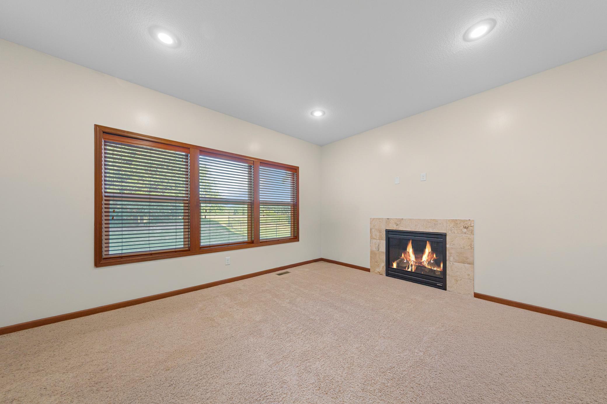 42_Living room featuring gas fireplace and stunning backyard views.jpg