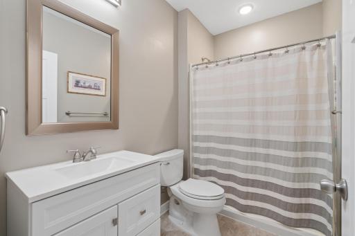 Modern finishes with a sleek vanity, framed mirror, and neutral tile â a clean, stylish design.
