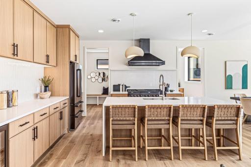 Chef's kitchen with black ZLINE appliances, white oak cabinetry with soft close doors and drawers, tons of counterspace, and a waterfall quartz island.